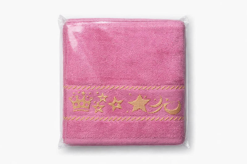 Pink baby towel with crown, stars, and moon embroidery, packaged in clear plastic