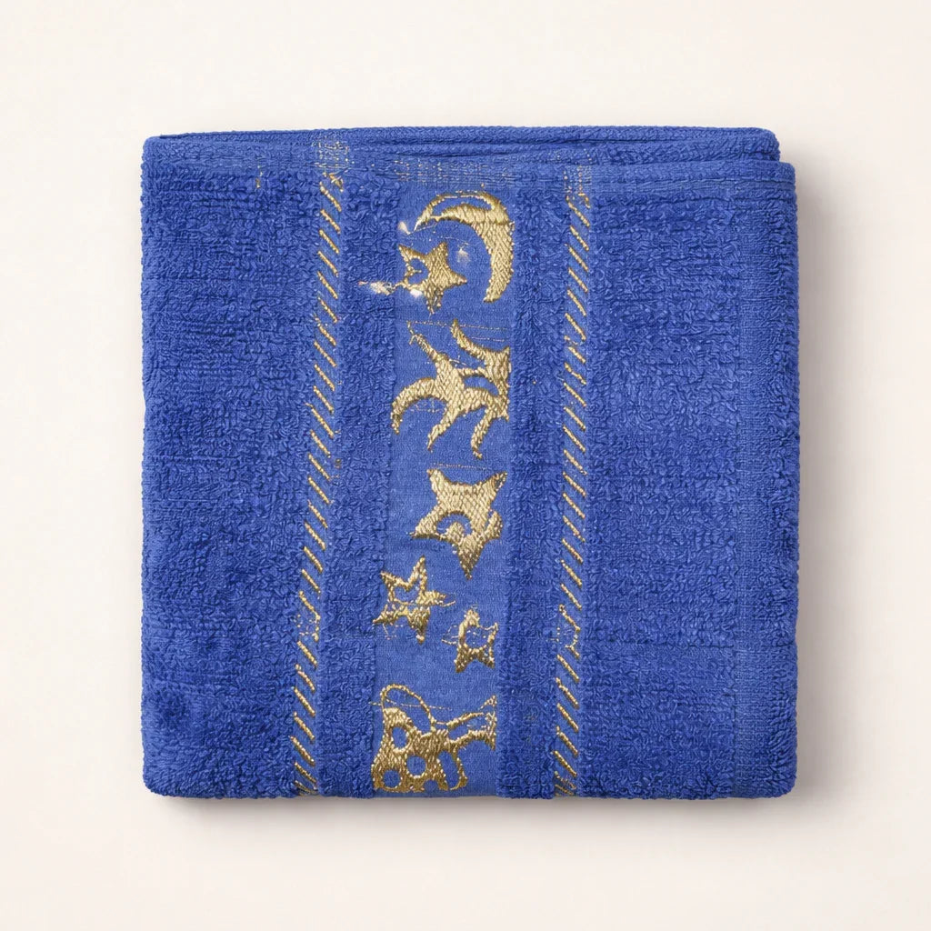 Blue kids towel with gold star and moon embroidery, folded on a light background.