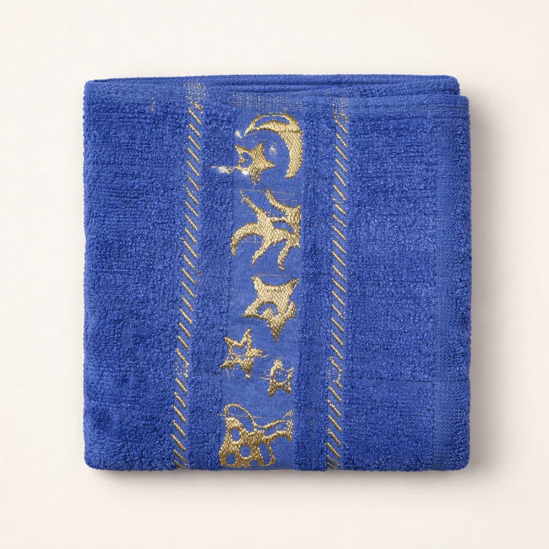 Blue kids towel with gold star and moon embroidery, folded on a light background.