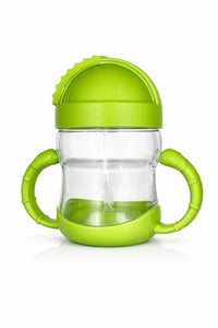 Green baby sippy cup with handles and spill-proof lid on white background
